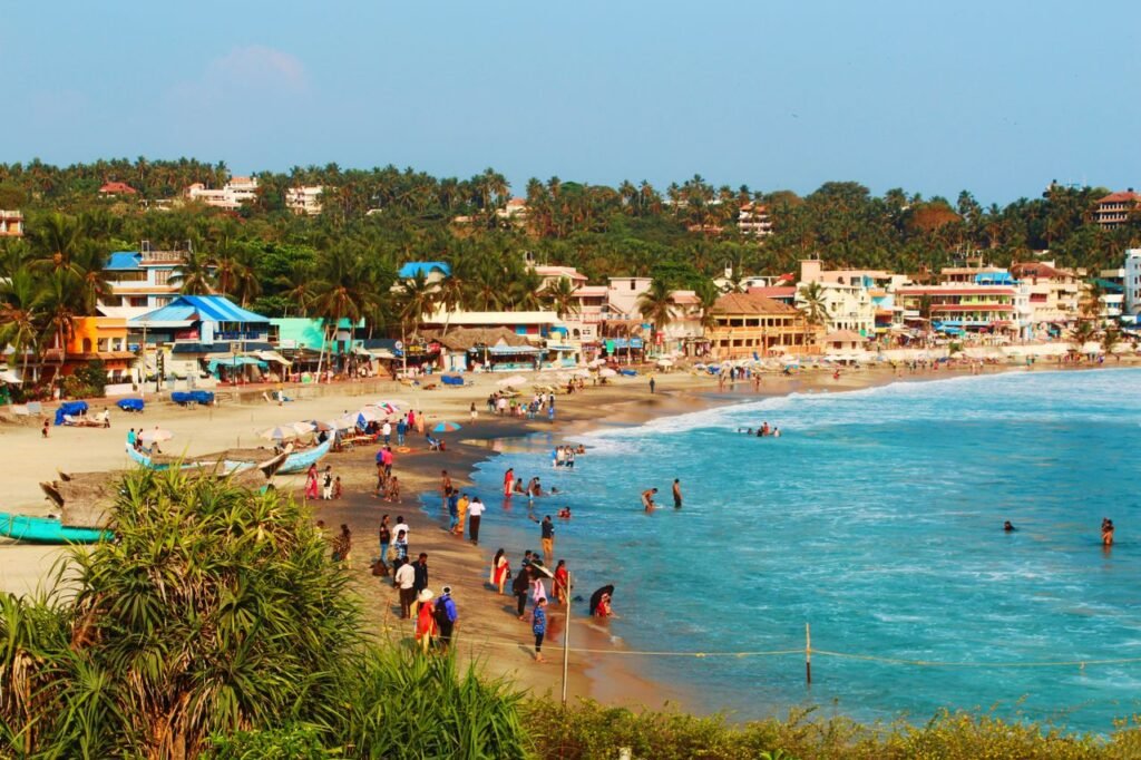 pexels photo 5245473 5245473 Beachfront village bustling with tourists, vibrant buildings, and palm trees on a sunny day.